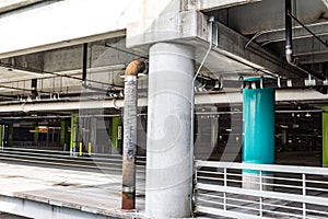 Interior of a parking garage with turquoise and green painted posts, pipes