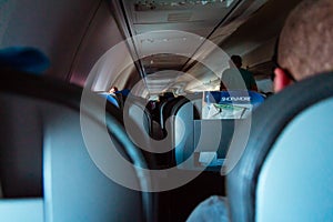 Interior of passenger airplane with people on seats