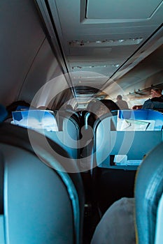 Interior of passenger airplane with people on seats