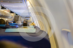 Interior of passenger airplane with people on seats