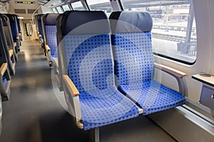 Interior of passenger train in Europe. Empty train wagon. Row of blue comfortable seats in train. Journey in Germany.