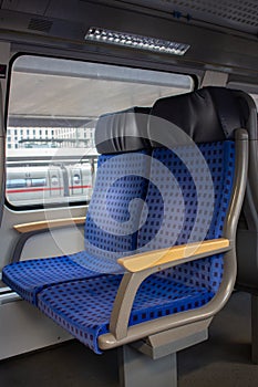 Interior of passenger train in Europe. Empty train wagon. Row of blue comfortable seats in train. Journey in Germany.