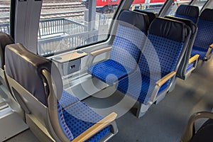 Interior of passenger train in Europe. Empty train wagon. Row of blue comfortable seats in train. Journey in Germany.