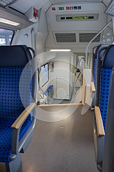 Interior of passenger train in Europe. Empty train wagon. Row of blue comfortable seats in train. Journey in Germany.