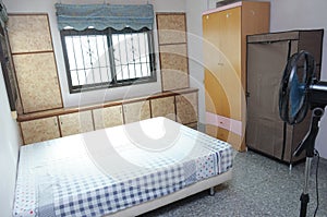 An interior photo of a bedroom with stand alone and flushed wall wooden wardrobe cardboard cabinets