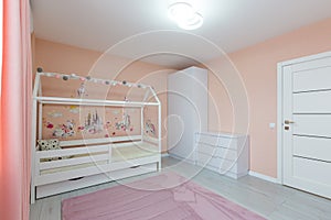 Interior photo children`s room for a girl of light color with pink, with a white cot