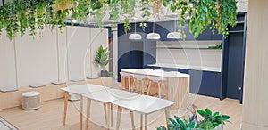 Interior photography of a modern office breakout area with kitchen, blue and grey cabinets, pendant lights, polished concrete