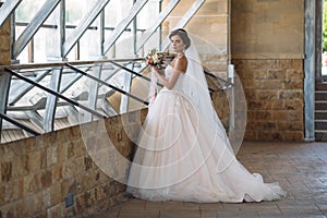 Interior portrait of gorgeous rbide in white wedding dress. Beautiful woman with bridal makeup and hairstyle. Amazing
