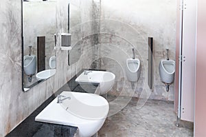 Interior of public clean toilet in a shared toilet there is wide selection of sinks with mirrors