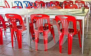 Interior of public dining area with colourul plastic chairs and tables