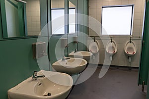 The interior of a public toilet or bathroom with sinks and urinals