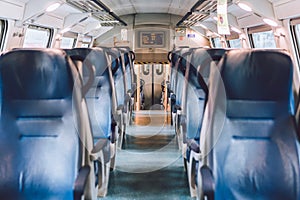 Interior of railway passenger car of the second class in train in Lombardy in Italy. Train interior. Blue seats in a commuter