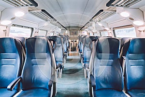 Interior of railway passenger car of the second class in train in Lombardy in Italy. Train interior. Blue seats in a commuter