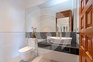 Interior real bathroom features basin, toilet bowl