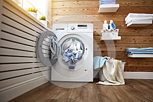 Interior of real laundry room with washing machine at window at