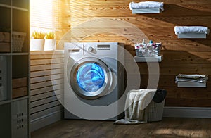 Interior of real laundry room with washing machine at window at
