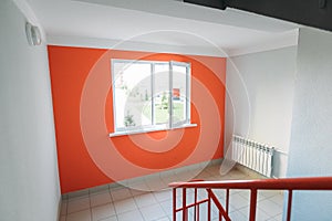 Interior of a residential building in white and orange colors with entrance doors