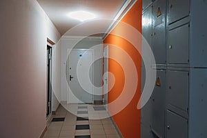 Interior of a residential building in white and orange colors with entrance doors