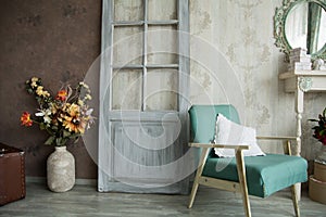 Interior retro room with an armchair, flowers, door and mirror