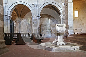 Interior of romanesque cathedral of Sovana with baptismal font