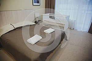 interior rooms with a balcony in the hotel, large double bed, cot, bedside table 1