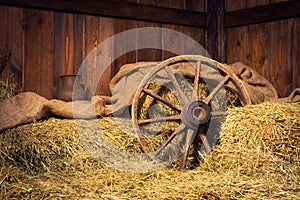 Interior of a rural farm - hay, wheel, pitcher