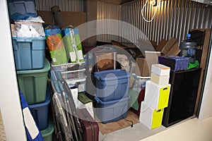 A storage unit full of boxes and plastic tubs photo