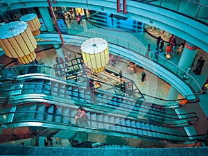 interior shopping mall structure of elevator with shopping women in teal color light