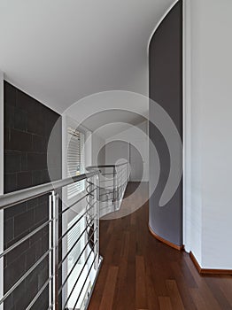 interior shot of a balcony with steel railing inside of a modern villa