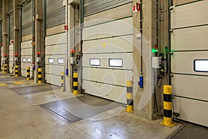 Interior shot of a warehouse with a row of doors and control panels next to it