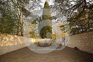 Interior of a small cemetery surrounded by majestic trees