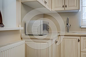 Interior of the small living equipped kitchen in studio apartments in minimalistic style with light color