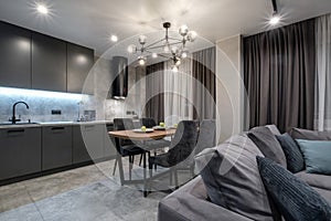 Interior of the small living equipped kitchen in studio apartments in minimalistic style with light color