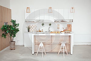 Interior of small white kitchen with fresh fruit, two glasses of orange juice, baguette, red caviar, croissant and
