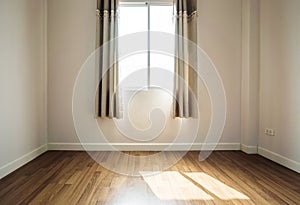 Interior space, empty room, laminate wooden floor with opened window receiving sunlight in the morning