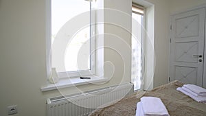 Interior of a spacious hotel bedroom on attic floor with fresh linen on a big double bed. Cozy contemporary mansard room in a mode