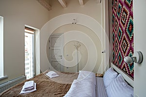 Interior of a spacious hotel bedroom with fresh linen on a big double bed. Cozy contemporary room in a modern house