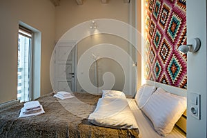 Interior of a spacious hotel bedroom with fresh linen on a big double bed. Cozy contemporary room in a modern house