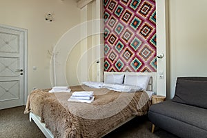 Interior of a spacious hotel bedroom with fresh linen on a big double bed. Cozy contemporary room in a modern house