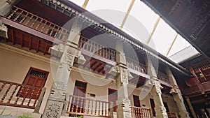 Interior of Sri Dalada Maligawa, Kandy, ornate wood carvings, traditional architecture with columns, railings, intricate