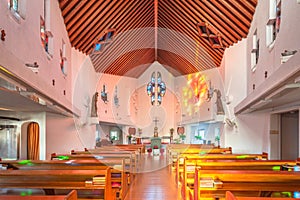 Interior of St Filippo Nishizaka Church in Nagasaki with a wooden ceiling and stained glass windows.