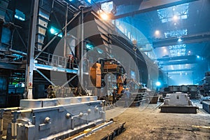 Interior of steel mill. Workers in workshop of metallurgical plant. Foundry and heavy industry building inside