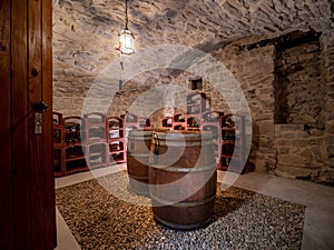 Interior of stony building with wine cellar with wine barrels