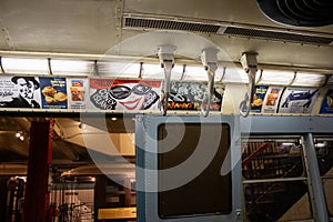 Interior of a subway train with multiple banners