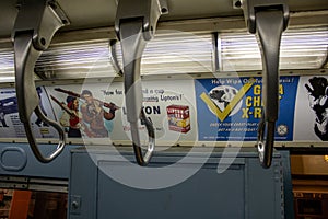 Interior of a subway train with multiple banners