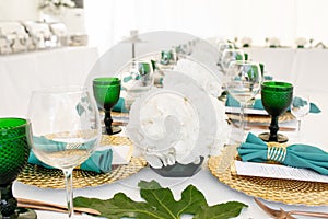 Interior of tent for wedding diner, ready for guests. Served round banquet table outdoor in marquee decorated hydrangea