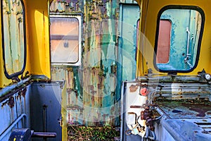 Interior of very old railway cockpit without doors, metal walls corroded
