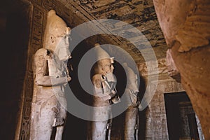 Interior View with an Ancient Egyptian Statues of Ramesses linked to the god Osiris in the Great Temple at Abu Simbel