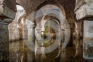 Interior view of the Arab cistern Caceres Spain, reflections of the arches in the water photo