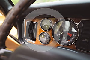 Interior view of a classic car, featuring a dashboard with a variety of dials and gauges